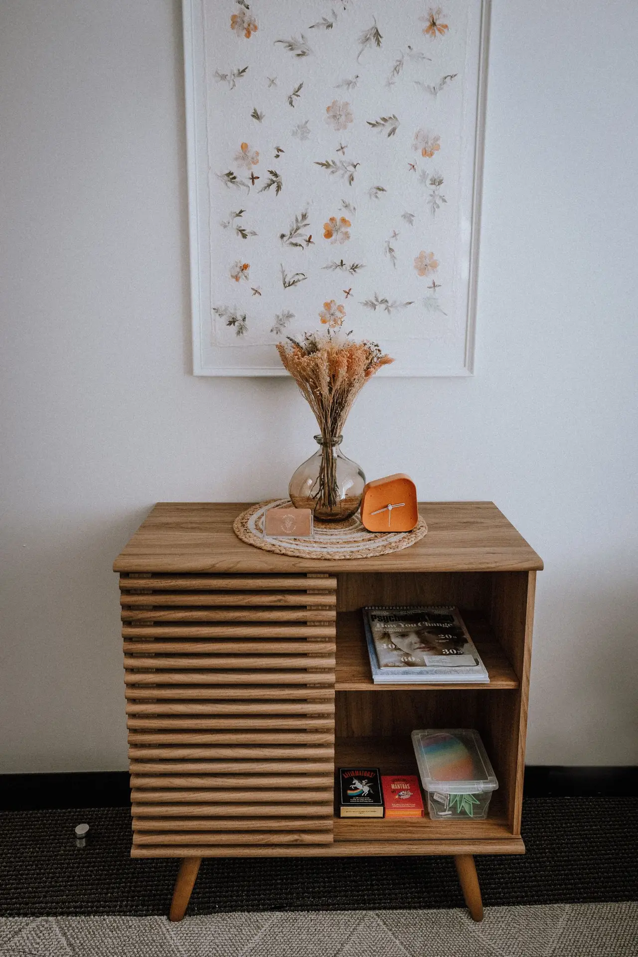 Wooden cabinet with a vase of dried flowers in The Nook Counselling office